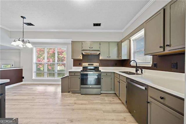 kitchen featuring sink, appliances with stainless steel finishes, hanging light fixtures, ornamental molding, and light wood-type flooring