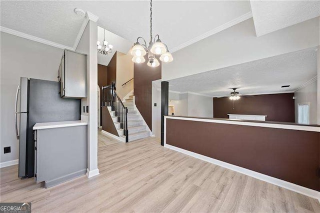 kitchen with pendant lighting, crown molding, a textured ceiling, and light wood-type flooring