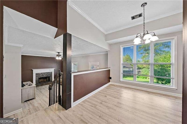 hall with crown molding, a notable chandelier, a textured ceiling, and light hardwood / wood-style flooring