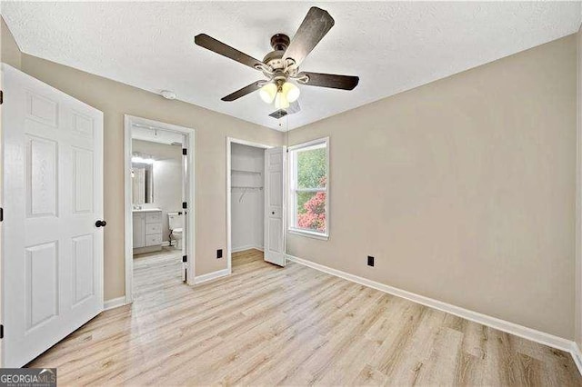 unfurnished bedroom featuring ceiling fan, light hardwood / wood-style flooring, a closet, and a textured ceiling