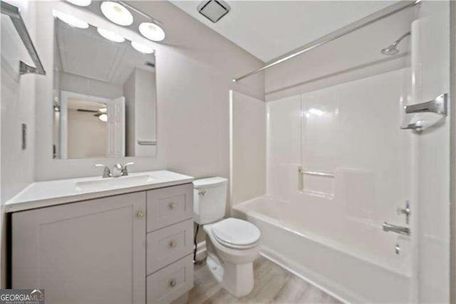 full bathroom featuring vanity, wood-type flooring, shower / bathtub combination, and toilet