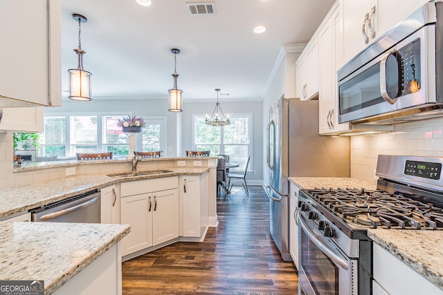 kitchen featuring visible vents, stainless steel appliances, crown molding, white cabinetry, and a sink