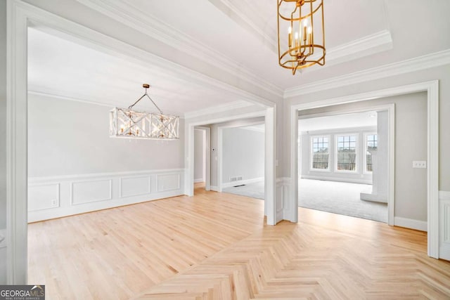 unfurnished dining area featuring an inviting chandelier, parquet floors, and crown molding