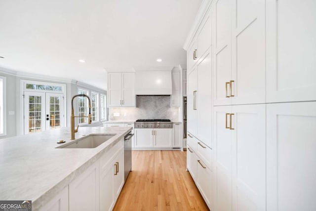 kitchen featuring white cabinetry, sink, backsplash, stainless steel appliances, and french doors