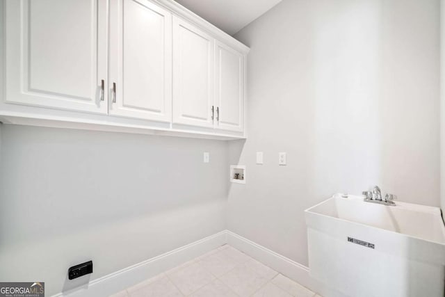 clothes washing area featuring sink, hookup for a washing machine, and cabinets