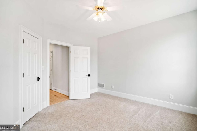 unfurnished bedroom featuring light carpet and ceiling fan