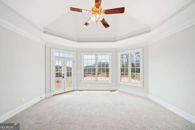 carpeted spare room with french doors, ceiling fan, a tray ceiling, and crown molding