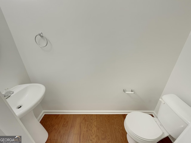 bathroom with hardwood / wood-style floors and toilet