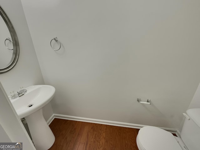 bathroom featuring hardwood / wood-style flooring and toilet