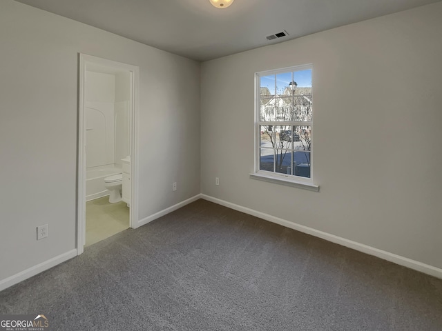 interior space featuring ensuite bathroom and carpet flooring