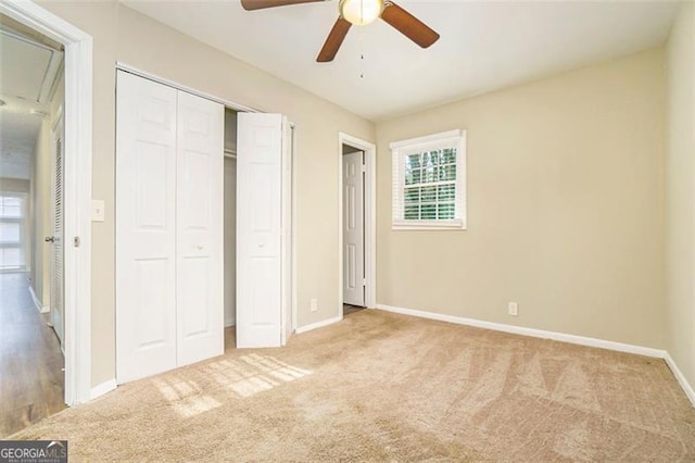 unfurnished bedroom with ceiling fan, a closet, light carpet, and multiple windows