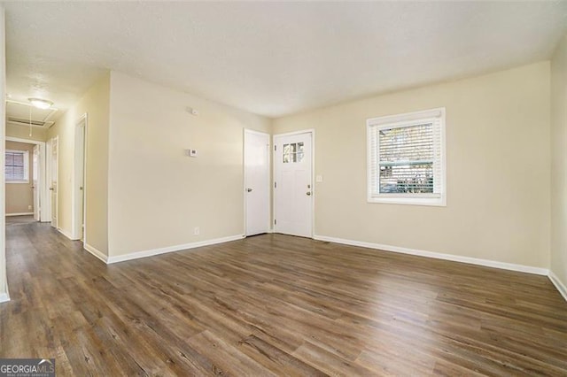 empty room with dark hardwood / wood-style flooring