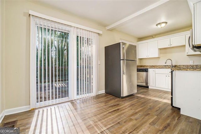 kitchen featuring stainless steel appliances, white cabinetry, dark hardwood / wood-style flooring, and beam ceiling