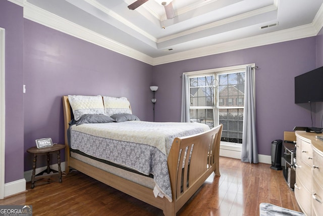 bedroom featuring crown molding, ceiling fan, dark hardwood / wood-style flooring, and a raised ceiling