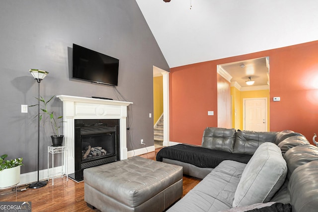 living room featuring hardwood / wood-style flooring, lofted ceiling, and ornamental molding