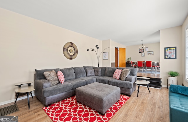 living room featuring wood-type flooring and a chandelier