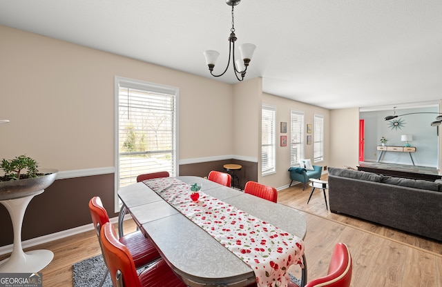 dining space featuring light hardwood / wood-style floors, a chandelier, and a healthy amount of sunlight