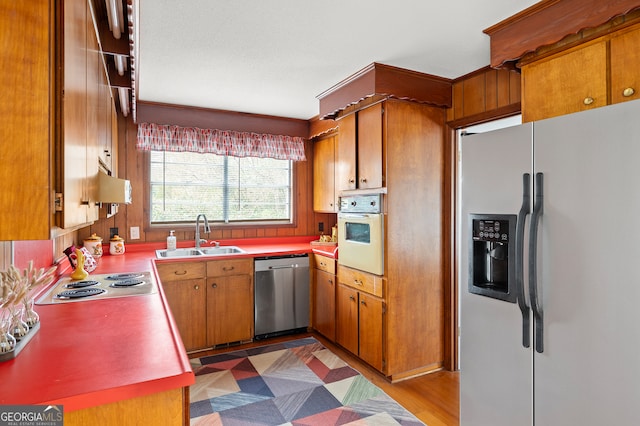 kitchen with appliances with stainless steel finishes, dark hardwood / wood-style floors, and sink