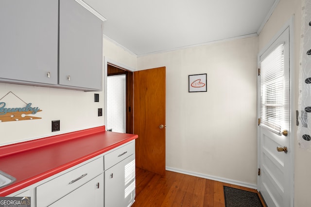 kitchen with hardwood / wood-style flooring and crown molding