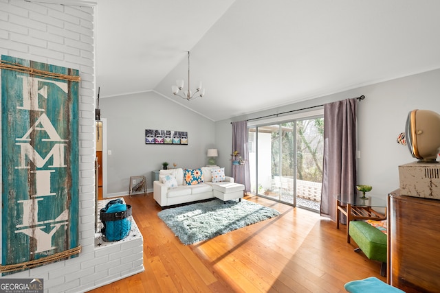 living room featuring a notable chandelier, hardwood / wood-style flooring, and vaulted ceiling