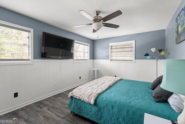 bedroom featuring ceiling fan, a textured ceiling, and dark hardwood / wood-style flooring