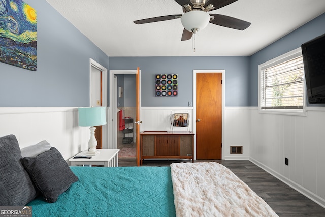 bedroom featuring ceiling fan, dark wood-type flooring, and a textured ceiling