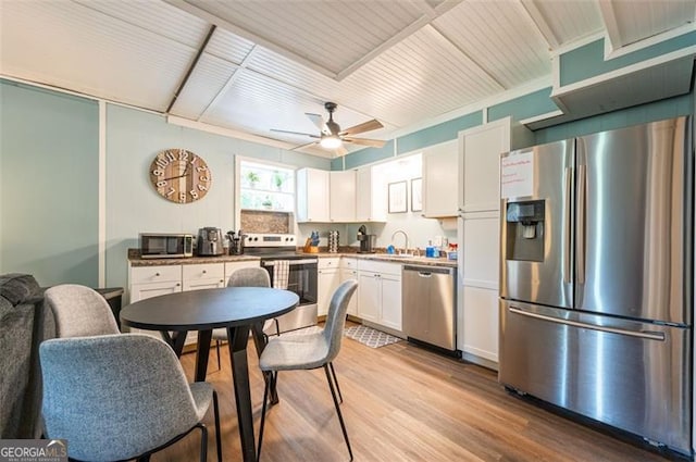 kitchen featuring sink, light hardwood / wood-style flooring, ceiling fan, appliances with stainless steel finishes, and white cabinets