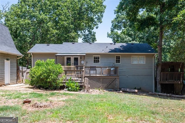 back of property featuring a deck and a lawn