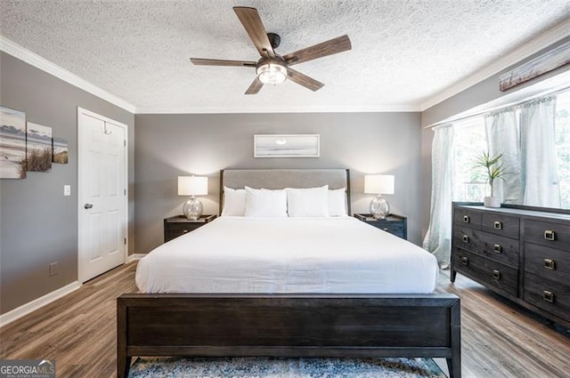 bedroom with a textured ceiling, wood-type flooring, ornamental molding, and ceiling fan