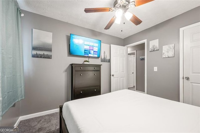 bedroom featuring ceiling fan, carpet, and a textured ceiling