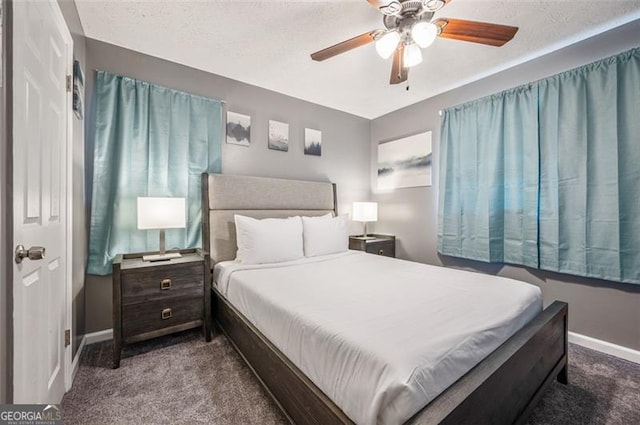 carpeted bedroom with ceiling fan and a textured ceiling