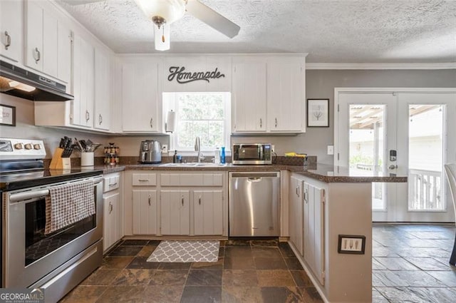4297 Earney Rd, Woodstock, GA 30188 - kitchen with appliances with stainless steel finishes, under cabinet range hood, stone tile floors, a peninsula, and dark countertops