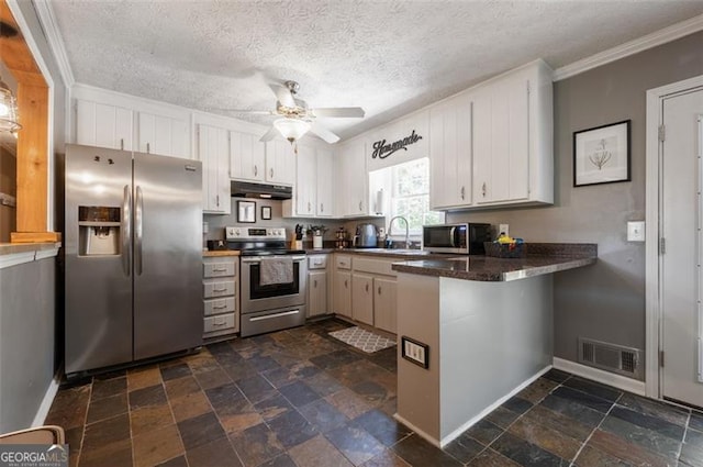 kitchen with appliances with stainless steel finishes, white cabinetry, sink, ceiling fan, and kitchen peninsula