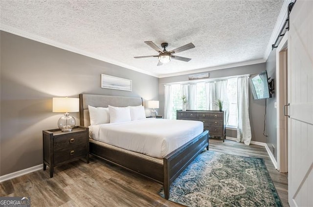 bedroom with crown molding, a barn door, hardwood / wood-style floors, and a textured ceiling