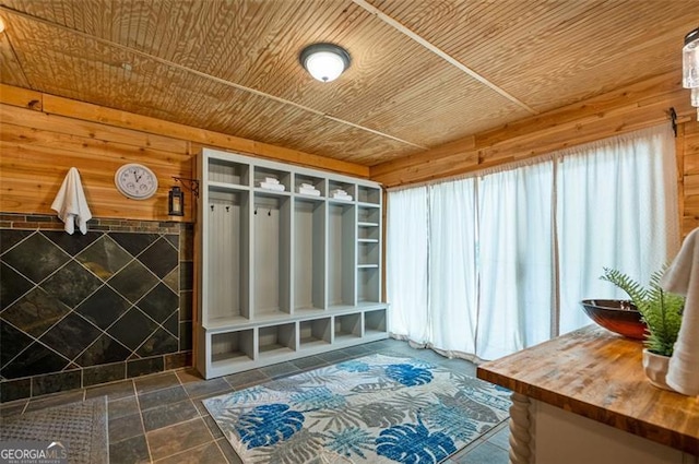 mudroom featuring wooden walls, a fireplace, and wood ceiling