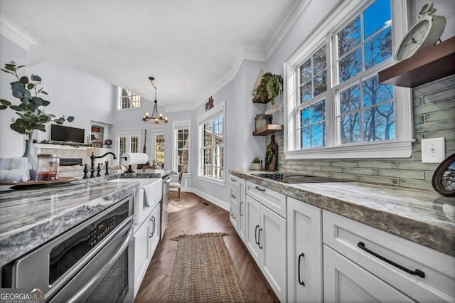 kitchen featuring crown molding, white cabinetry, dark hardwood / wood-style floors, light stone counters, and decorative light fixtures