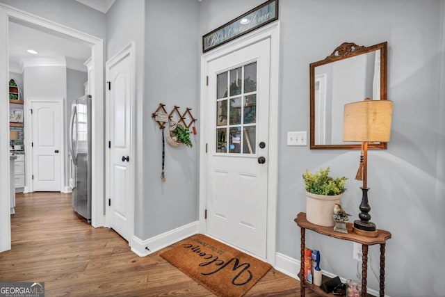 entrance foyer with light hardwood / wood-style flooring and ornamental molding