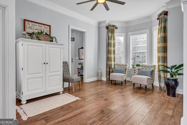 sitting room with ornamental molding, ceiling fan, and light hardwood / wood-style floors