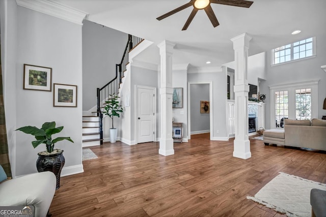 living room with hardwood / wood-style flooring, crown molding, and ornate columns