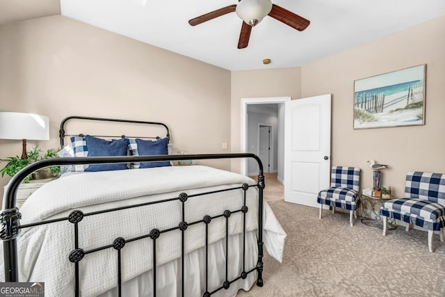 bedroom with vaulted ceiling, light colored carpet, and ceiling fan