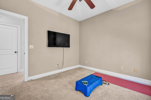 exercise area featuring light colored carpet and ceiling fan