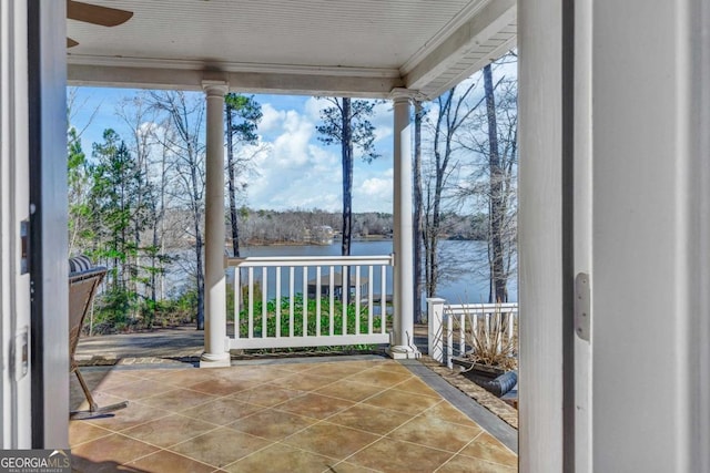 unfurnished sunroom featuring decorative columns and a water view