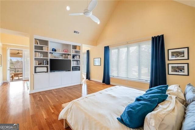 bedroom with ceiling fan, high vaulted ceiling, and light hardwood / wood-style flooring