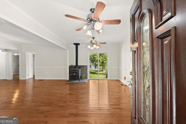 unfurnished living room with wood-type flooring and a wood stove