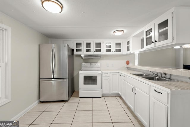 kitchen featuring sink, light tile patterned floors, stainless steel fridge, white range with electric stovetop, and white cabinets