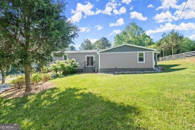 rear view of property featuring a yard