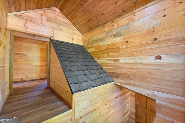 interior space featuring wood-type flooring, wooden walls, and wooden ceiling