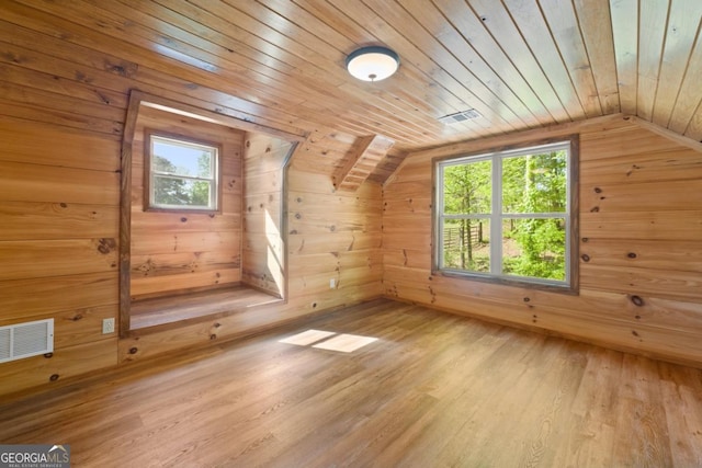 additional living space featuring wood ceiling, light wood-type flooring, vaulted ceiling, and wood walls