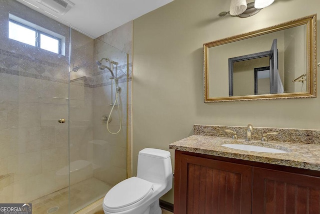 bathroom with vanity, a shower with shower door, and toilet