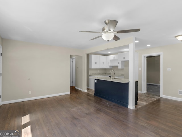 unfurnished living room with dark wood-type flooring, ceiling fan, and sink